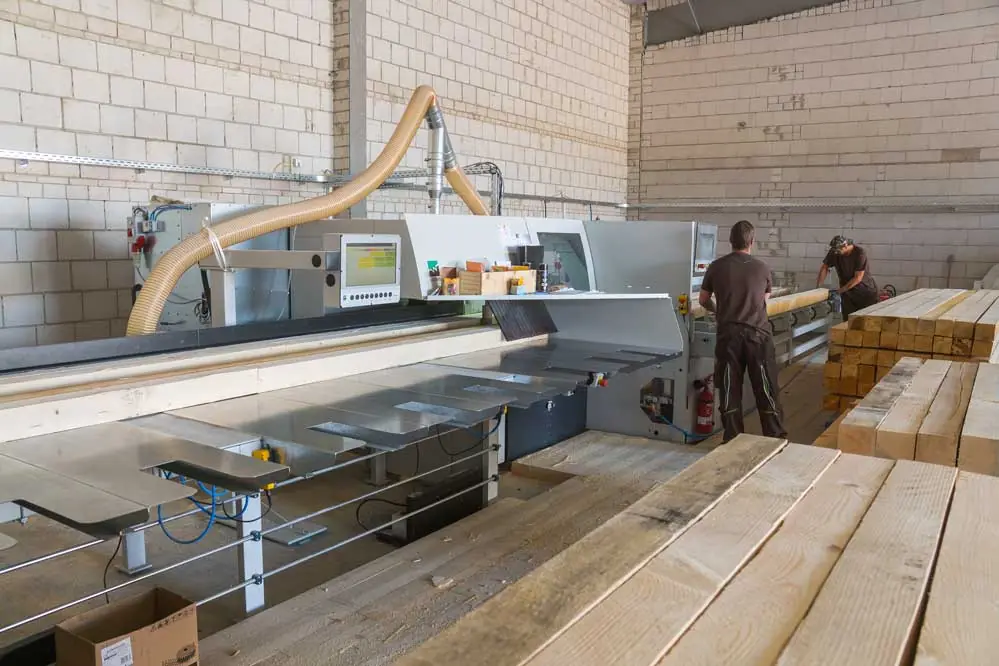Zwei Mitarbeiter an einer Zuschnittanlage in der Werkhalle
